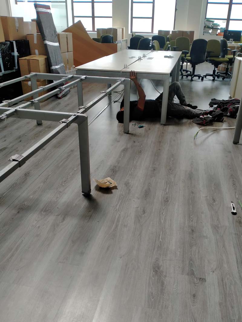 PORTES Y MUDANZAS MEGA hombre desarmando mueble de oficina